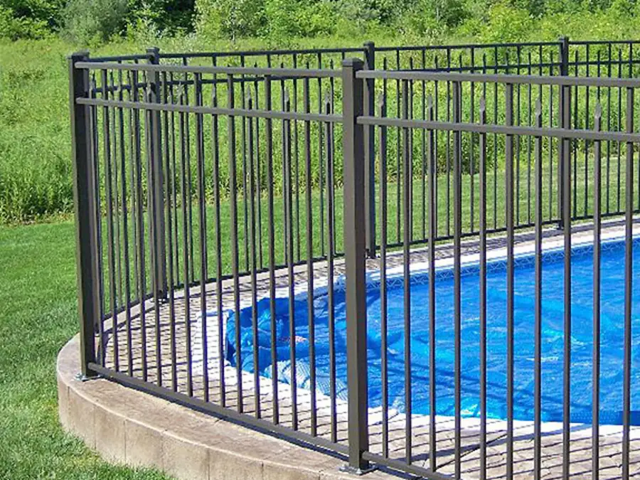 Black aluminum pool safety fence around an inground pool