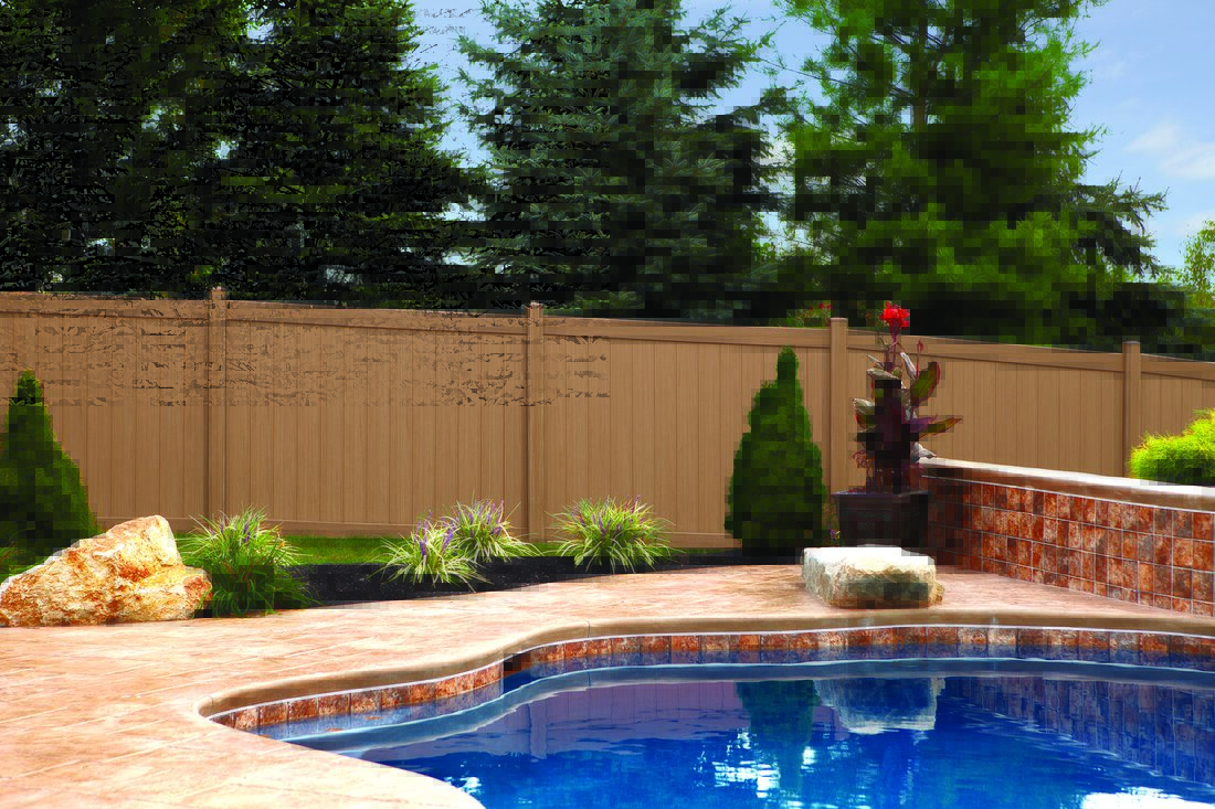 Tan vinyl privacy fence enclosing an inground pool and patio