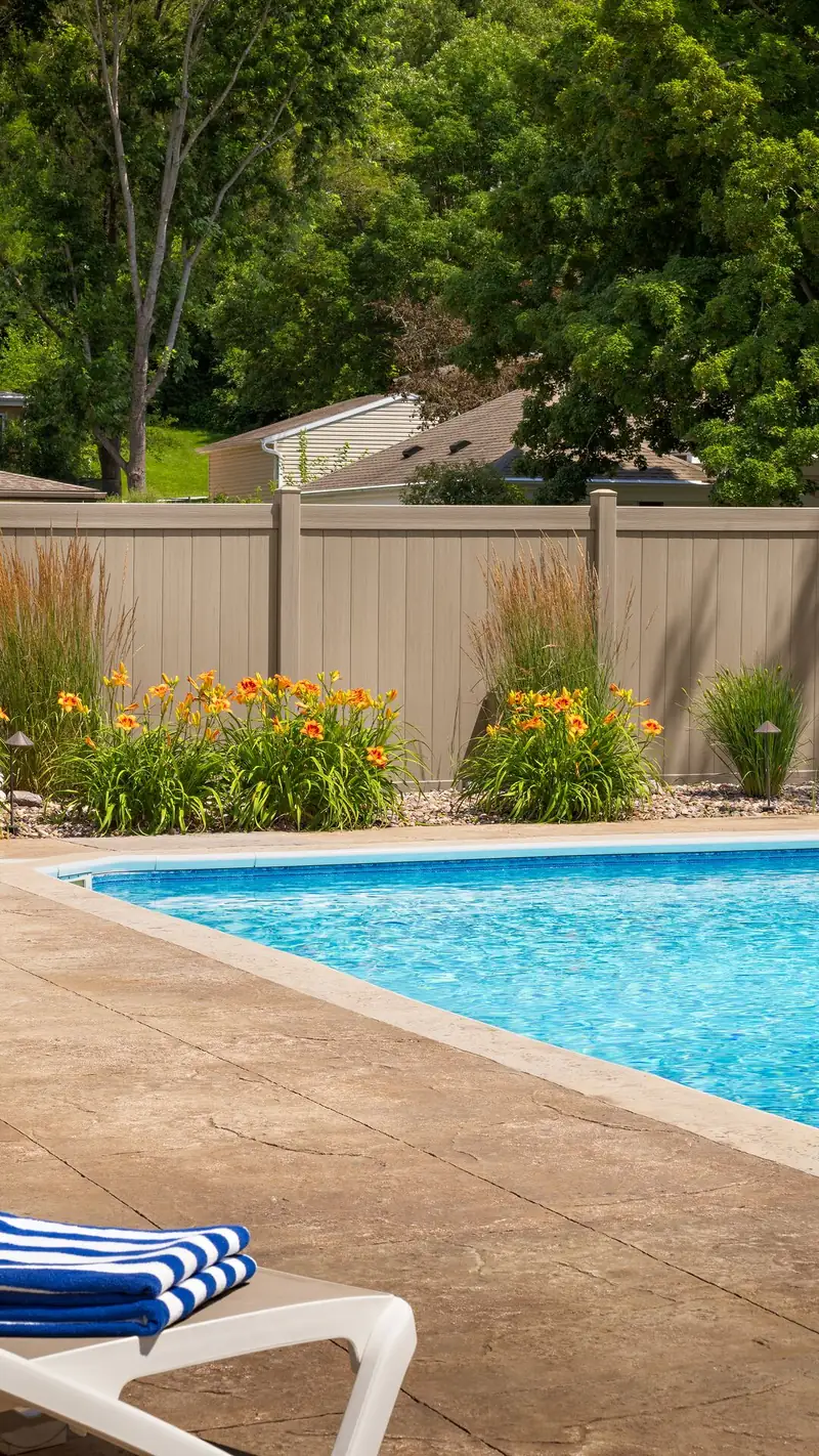 Tan vinyl privacy fence around a backyard pool in Chesterfield